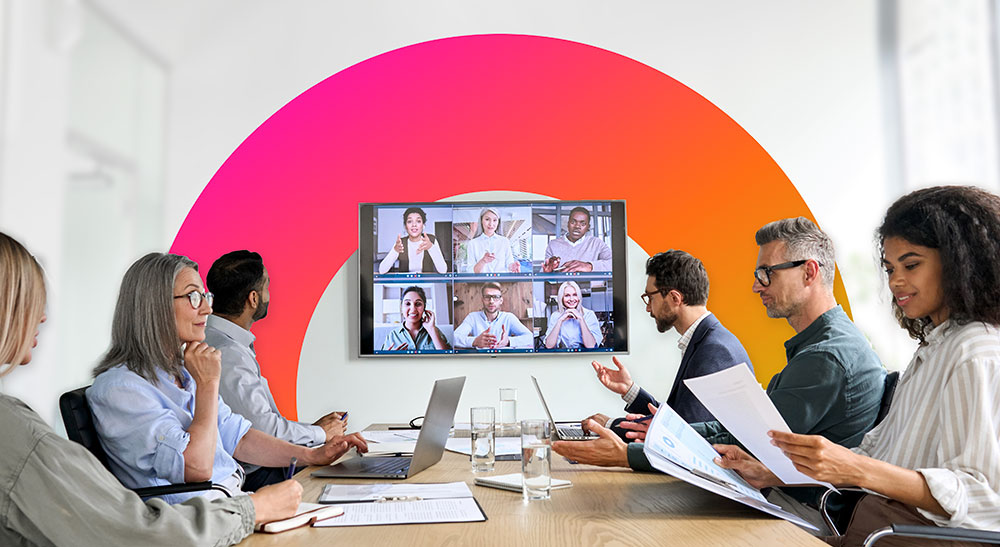 A group of people in a meeting room participating in a video conference.