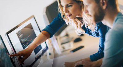 Two colleagues are engaged in a collaborative digital project on a computer screen, symbolizing the synergy between teamwork and modern technology