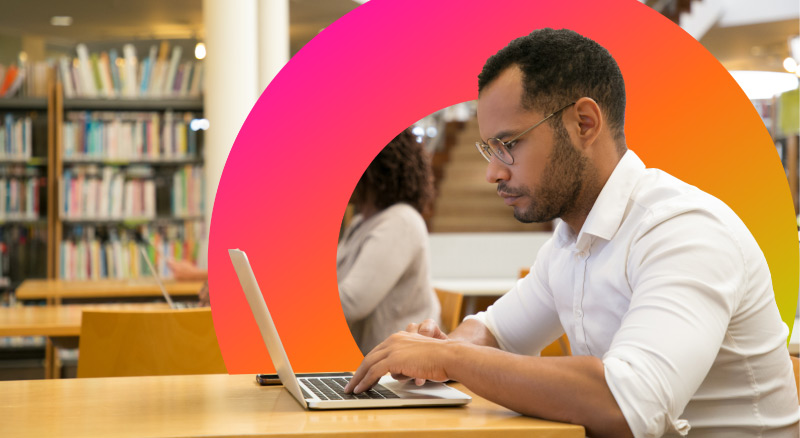 A person working on a laptop in a library