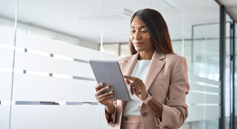 A person holding a tablet in a modern office environment