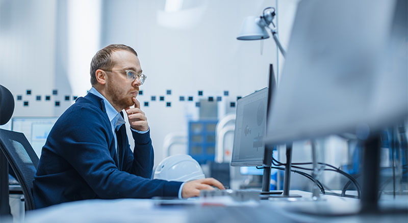 A professional man in a suit focused on his work at a computer.