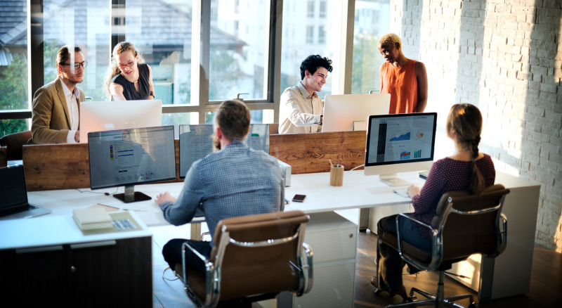 Four professionals having a discussion around a table in an office setting