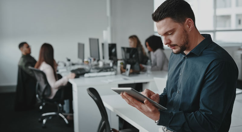 A person coding on a computer with multiple monitors