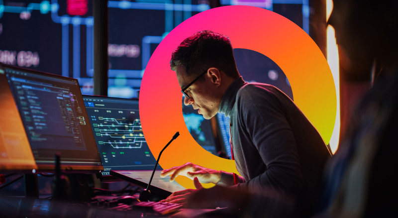 A person engaged in a task at a multi-monitor computer station