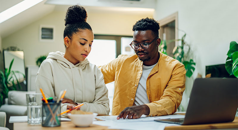 A young couple collaborating on a  project, focusing on the task at hand with determination and teamwork.