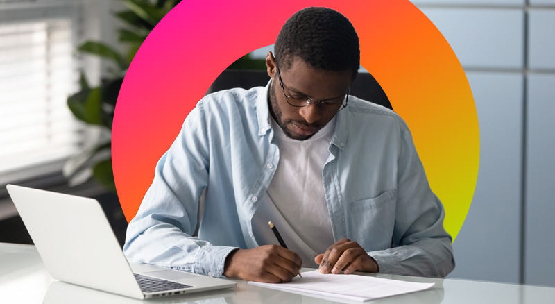 Man signing contract infront of his laptop