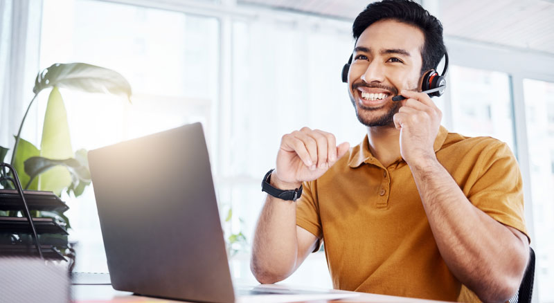 Smiling man adjusts microphone on headset