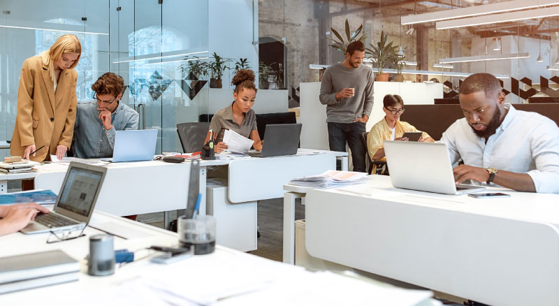 Group of various employees working in an open concept office space