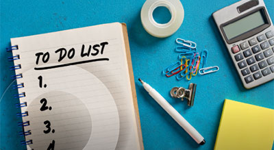 A notebook labeled with To Do List among office supplies