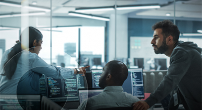 A diverse group of professionals collaborating at computers in a modern office environment