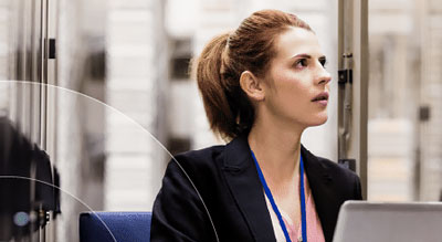 A person sitting in an office with a laptop in front of them looking upwards