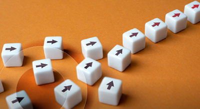 Multiple 6 sided dice with an arrow point the same way on an orange background