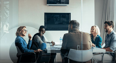 A group of individuals sitting around a table in a meeting room environment