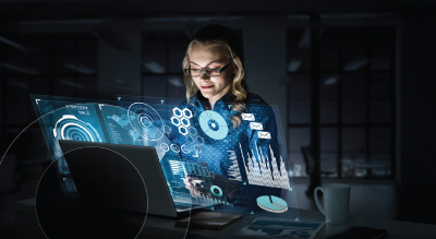 A person wearing glasses intently observes a laptop screen displaying a digital interface