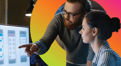 Two individuals in front of a computer screen in an office environment