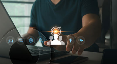 Close up of a person using a laptop while interacting with holographic icons