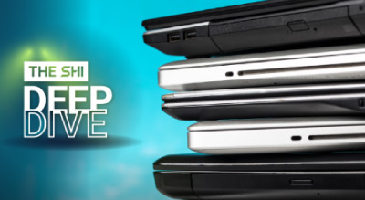 Several closed laptops stacked horizontally, showing different device sizes and finishes