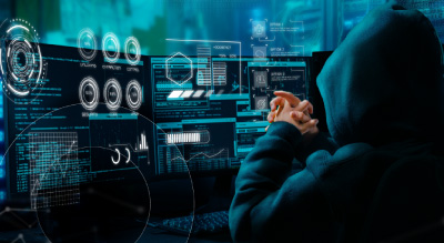 A person in a hoodie focused on a computer screen