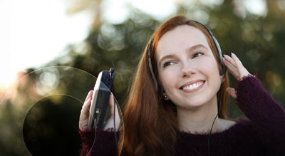 A person smiling while listening to music through headphones