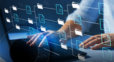 A person types on a laptop displaying a network diagram, illustrating connections and data flow in a digital environment