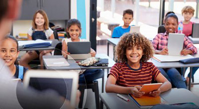 A group of students sit in desks in a classroom