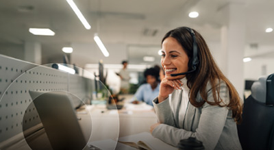 A female employee in office with headset on, using microsoft teams