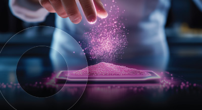 A hand sprinkles glowing pink particles over a rectangular digital surface in a futuristic lab. The atmosphere is high-tech and innovative.