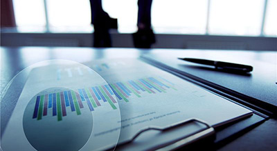 a close up of a document on a clipboard next to pen and laptop