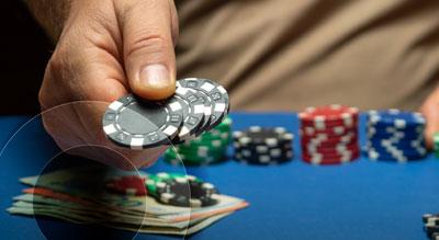 A hand placing multiple poker chips down for a bet