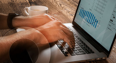 A pair of hands typing on a laptop