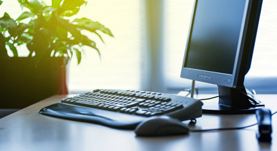 A serene workspace with a computer set against a window, illuminated by natural light