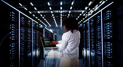 An employee holding a laptop in an ai data ccenter