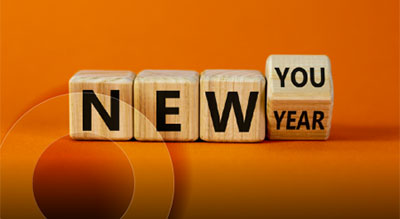 Wooden blocks arranged to display the phrase 'New You Year' against an orange background