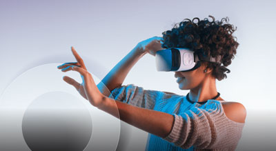 A person is immersed in a virtual reality experience, wearing a VR headset and interacting with invisible elements