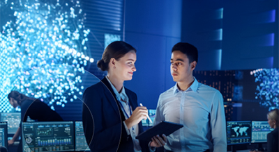 Two individuals collaborating in front of a computer screen, focused on their work
