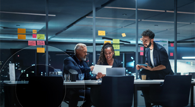 A group of professionals engaged in discussion around a table in a modern office setting
