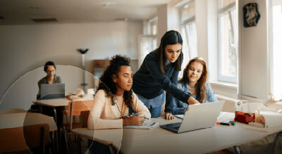 A group of people collaborating around a laptop.