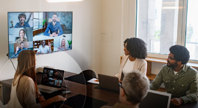 A group of employees in an office meeting room looking up at screen