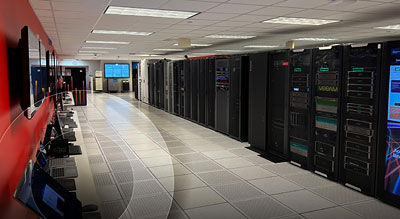 A modern data center with rows of high-tech servers illuminated under artificial lighting