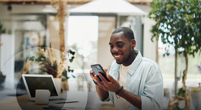 An excited person uses their mobile device in a brightly lit office