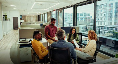A group of employees huddled using microsoft 365 products