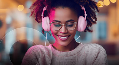 A person wearing headphones works on a laptop