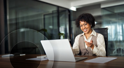 An individual engaged in a video conference sitting behind a laptop