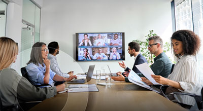 An office full of employees during a hybrid team meeting