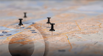 Close-up view of a map with black pushpins marking specific locations