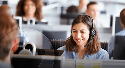 An office environment with employees wearing headsets working at their desks