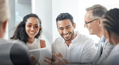 A group of people laughing and talking in an office setting