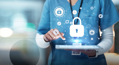A medical professional in scrubs uses a tablet displaying security UI