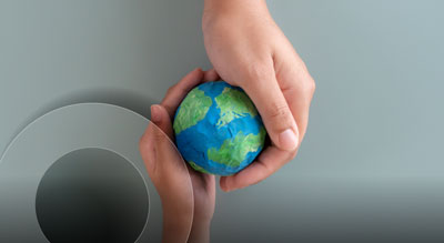 Two hands holding a miniature globe made of clay