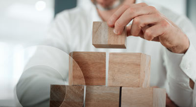 An individual stacking wooden blocks in a tower